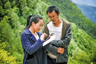 ▲李金莲(左)为村民讲解劳动法(5月5日摄)。新华社记者孙敏摄