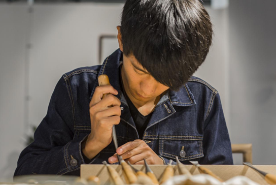 施彬林正在雕刻作品