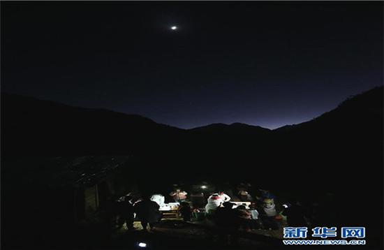 在云南怒江贡山县丙中洛镇碧汪村,来自贡山县丙中洛镇卫生院的医务人员借着手电筒的灯光为村民夜诊(1月12日摄)。
