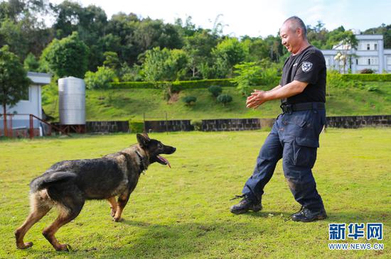 李华和警犬“化煌马”。(新华网 罗春明 摄)