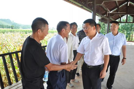 ▲毛宗晦与村组干部亲切握手