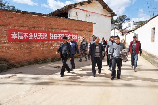 毛宗晦(前右一)在塔瓦村调研脱贫攻坚工作