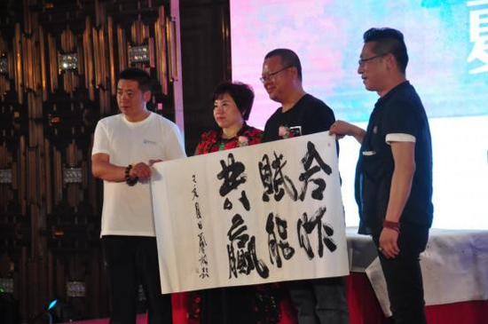 光明日报出版社原副社长兼副总编辑、光明日报书画院院长、联合国世界和平文化大使、著名画家王林先生(右起第二位)书赠“合作、赋能、共赢”墨宝