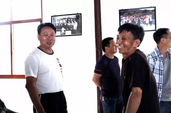 杨为文(左)走访“彝族花灯”非遗传承人白家顺(前右)