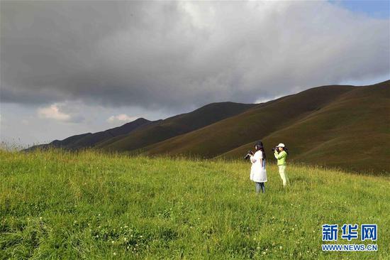 8月27日,游客在大海草山拍摄美景。