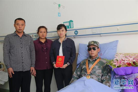 南部战区陆军云南扫雷大队在病房内为杜富国举行颁授一等功证书证章仪式后,杜富国与家人合影(11月24日摄)。