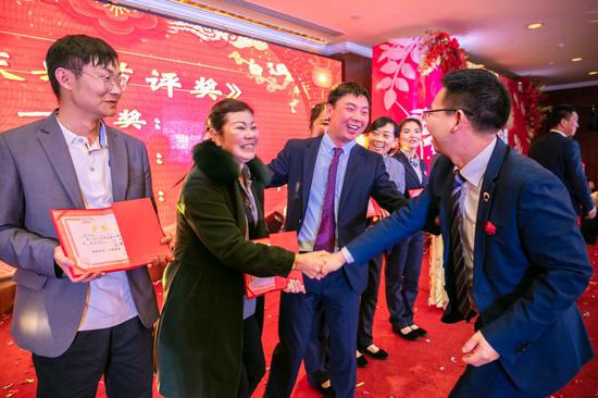 云瑞物业董事长简国帅在给员工颁奖