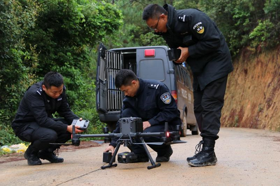 民警正在为无人机更换电池、做航前检查