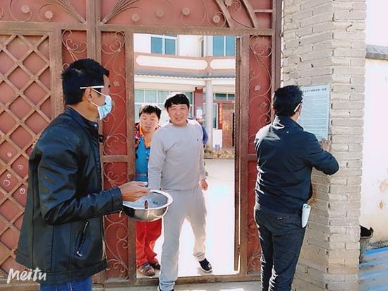 乡村干部逐户粘贴疫情防控宣传材料