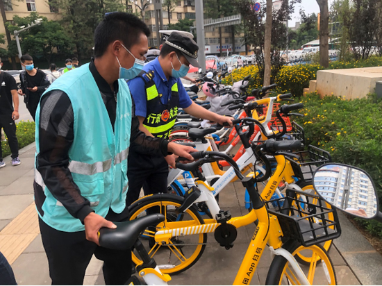 现场活动人员对乱停放车辆进行修整