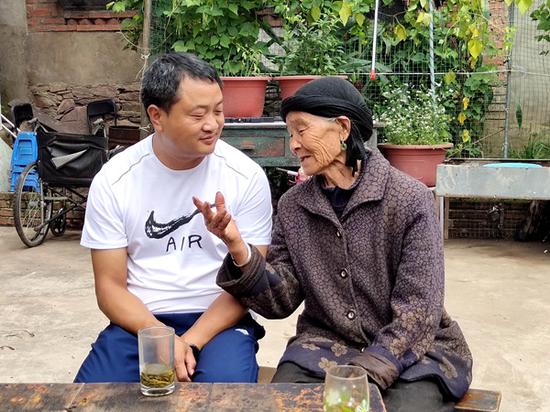 沈亮均听着罗信母亲絮叨。供图