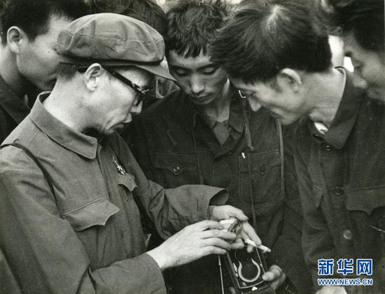 1969年,杨长福(左1)在和摄友们交流。受访者供图