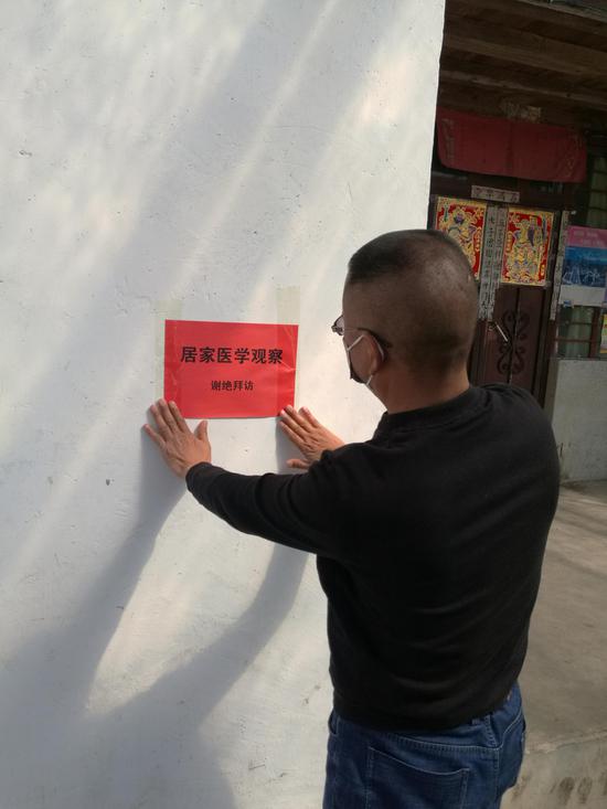 工作队员粘贴宣传标语