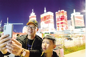 家住世纪城的李先生一家,刚走出东风广场地铁站就被美景留住脚步,拿出手机合影留念。