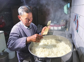 高家恩老人在 专门的厨房里蒸糯米