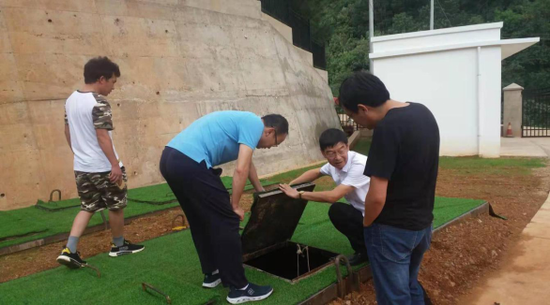 (图为尹贵生主任到赤松坪小组查看污水处理站情况)