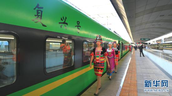 穿着民族服饰的列车员走过“复兴号”