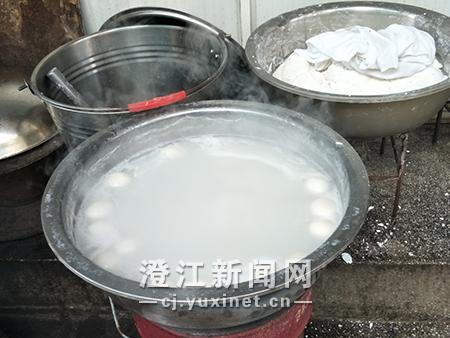 铁锅里,煮熟的手工汤圆漂浮在水面。