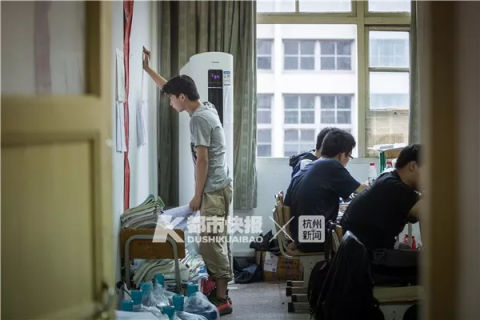 一名男生在教室后面的墙上查看试卷习题答案。记者 陈中秋 摄