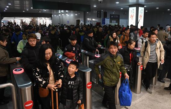 图为:众多旅客通过闸机出站。 王刚 摄