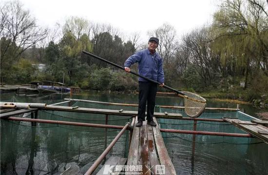 西湖渔老大老董在捞鱼。