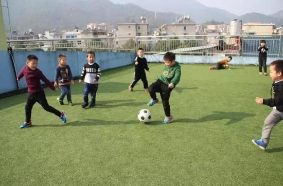 庆元县中心幼儿园的孩子们在开心地踢足球