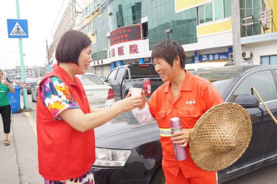 图为:义工开展献爱心送凉茶服务活动现场。高跃贵 摄