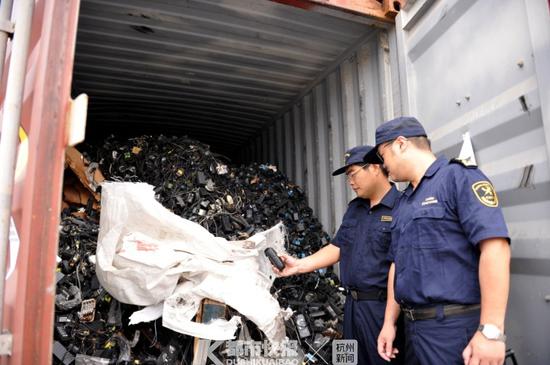 海关关员对固体废物进行查验 受访者供图 摄影 | 陈叶