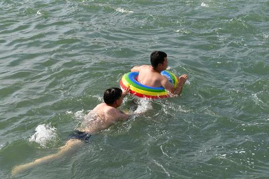 本周金华气温突破38℃,市民纷纷前往市区铁堰等地游泳找清凉。时补法摄