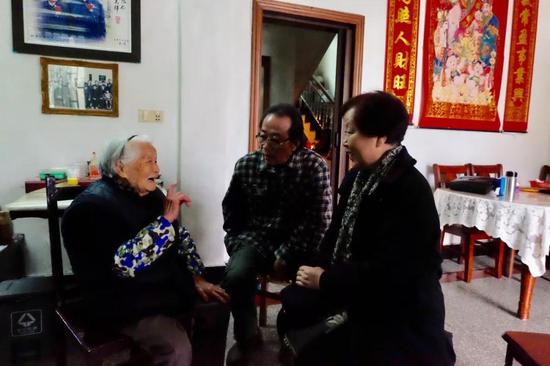 胡汉英和胡汉平在招士湾村和闾儒香儿时的玩伴王水英在一起交谈