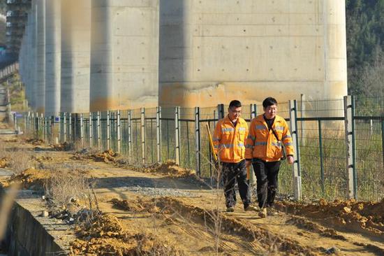 (姚旭和李然在巡查衢九铁路桥梁下方 本报记者 吴崇远/摄)