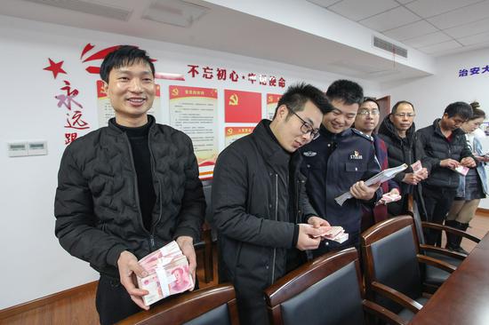 图为:7名员工领会了被拖欠4年之久的工资 喻跃翔 摄