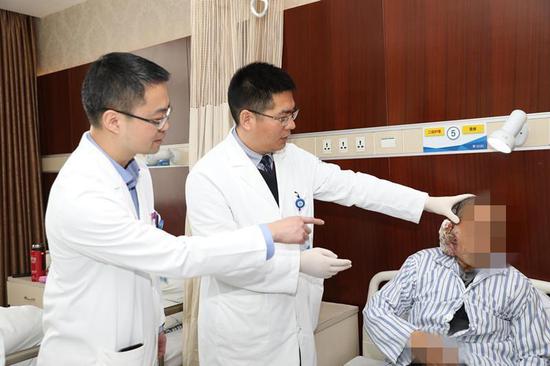 葛明华教授(中)与郑铭传主任(左一)察看杜大伯病情
