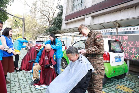 官兵们为社区居民剪头发。武警浙江省总队机动支队供图