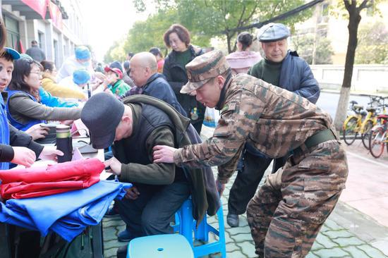 支队官兵们细心地为居民检查身体。武警浙江省总队机动支队供图
