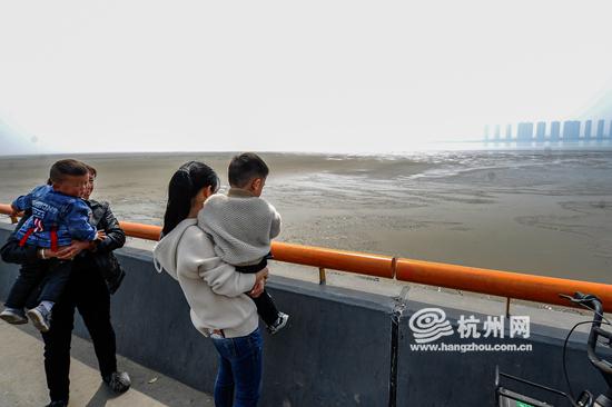 家住下沙附近的不少居民,带着孩子来看这难得的景象。