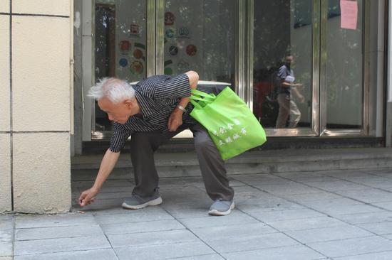 钱元明上街捡烟蒂 陈玉兰 摄