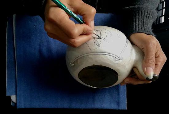 画师在毛样上用铅笔绘画,工匠再雕刻出精美的作品。 记者 包敦远 摄