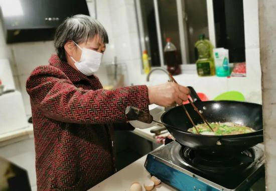 戴女士婆婆章荷金在给媳妇做美味的面条。