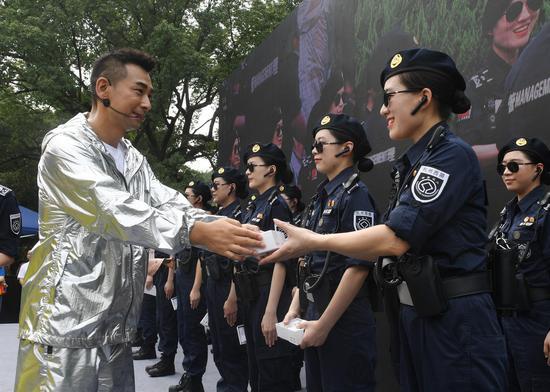 图为:赵文卓向西湖女子巡逻队赠送纪念物。王刚 摄