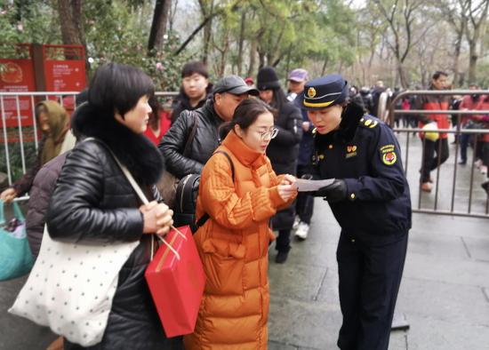 图为:西湖女子巡逻队队员为游客提供服务帮助。西湖景区执法局摄