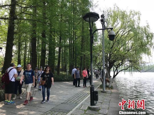 西湖边游览的游客和市民。(图文无关) 张斌 摄