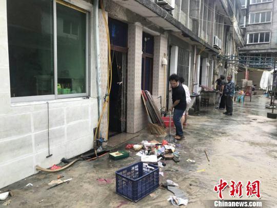南舥艚村民正打扫海水倒灌带来的垃圾。 胡哲斐 摄