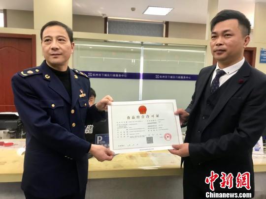 杭州试点直营连锁餐饮经营企业“评审承诺制”颁发的首张证件。 刘方齐 摄