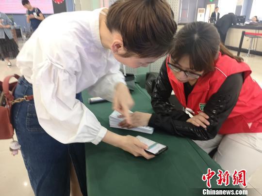 市民向志愿者咨询如何使用电子社保卡。 张煜欢 摄