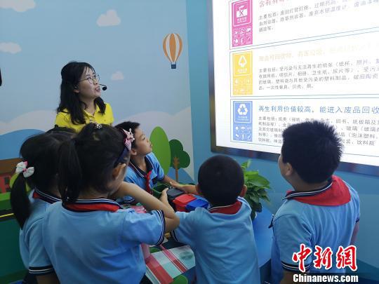 讲解员向小学生介绍垃圾分类知识。 张煜欢 摄