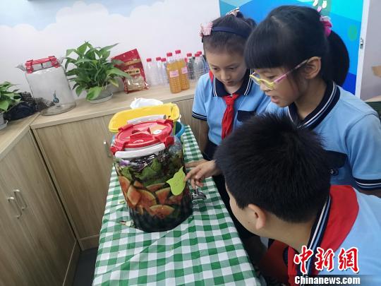 小学生们学习如何制作水果酵素。 张煜欢 摄