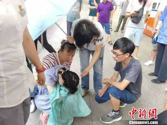 陈玉英(身着白衣者)询问发病女孩身体情况。桐乡卫校提供