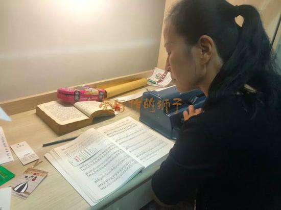 妈妈正在为女儿打盲文乐谱。张宇璐摄