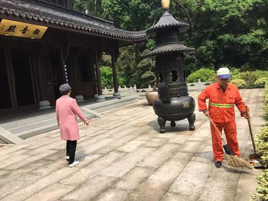 昨天,杨叔在虎跑观音殿前扫地。